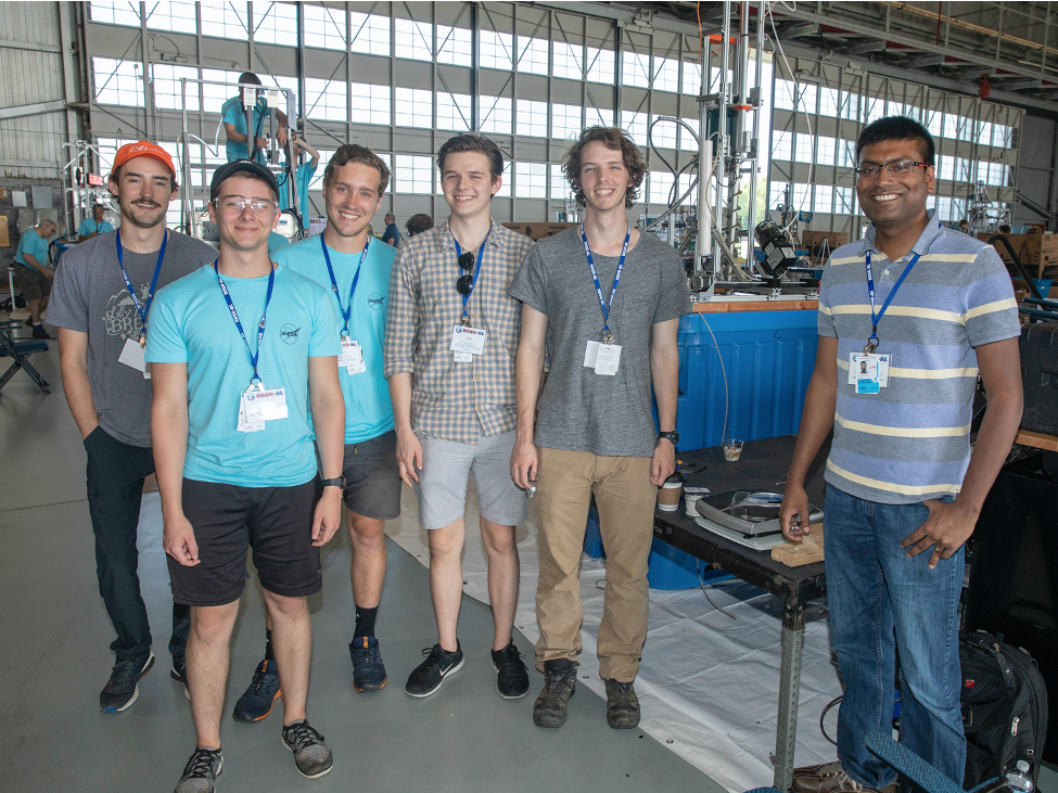 UT students, faculty advisor Dr. Chakraborty, and their robotic ice drill during a NASA competition